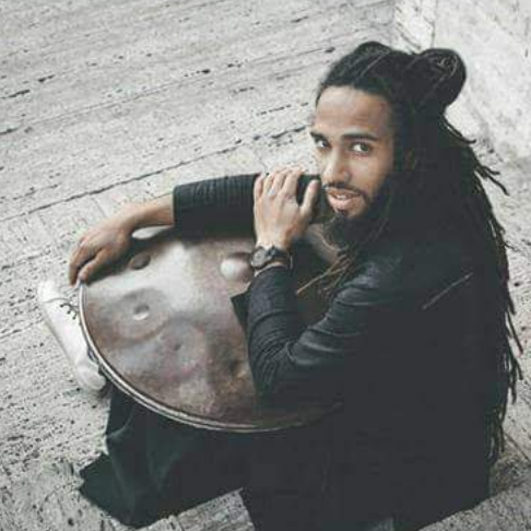 Man smiling above handpan musical instrument